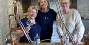 Smiling Visitors at a Gin Making Workshop at Black Cat Distillery at Brougham Castle near Penrith, Cumbria