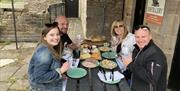 Smiling Visitors at a Gin Making Workshop at Black Cat Distillery at Brougham Castle near Penrith, Cumbria