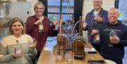 Smiling Visitors at a Gin Making Workshop at Black Cat Distillery at Brougham Castle near Penrith, Cumbria