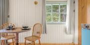 Interior of Bluebell Lodge, with kitchenette and dining setup, at Coniston Shepherd Hut Lodges in Coniston, Lake District