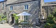 Exterior and outdoor seating at The Old Farmhouse at Brackenthwaite Farm near Arnside