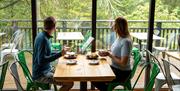 Couple enjoying lunch at at Cafe Ambio in Whinlatter Forest in the Lake District, Cumbria