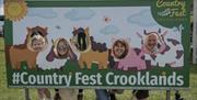 Visitors pose at a photo board at Country Fest in Crooklands, Cumbria