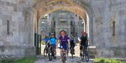 Cyclists Riding Through the Gates at Lowther Castle & Gardens in Lowther, Lake District