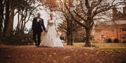 Bridal couple walking the grounds at Abbey House Hotel & Gardens in Barrow-in-Furness, Cumbria