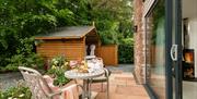 Outdoor seating and hot tub at Dandelion Cottage at Dandelion & Hoglet Cottages, near Dalston, Cumbria