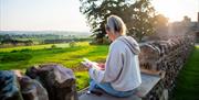 Woman Reading and Enjoying the View at Eden Heights Glamping in Appleby-in-Westmorland, Cumbria