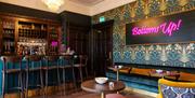 Bar Room with Neon Sign Saying "Bottoms Up!" at Fallbarrow Hall in Fallbarrow Hall in Bowness-on-Windermere, Lake District