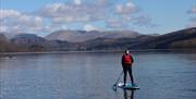 Visitors Paddleboarding with Genuine Adventures in the Lake District, Cumbria