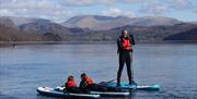 Visitors Paddleboarding with Genuine Adventures in the Lake District, Cumbria