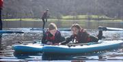 Visitors Paddleboarding with Genuine Adventures in the Lake District, Cumbria