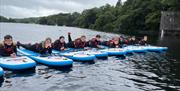 Visitors Paddleboarding with Genuine Adventures in the Lake District, Cumbria