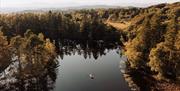 Aerial View of the Bridal Couple on a Rowboat at a Wedding at The Gilpin Hotel & Lake House in Windermere, Lake District