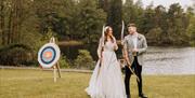 Bridal Couple doing Archery at a Wedding at The Gilpin Hotel & Lake House in Windermere, Lake District
