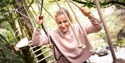 Visitor on a Rope Bridge at Go Ape in Whinlatter Forest Park in Braithwaite, Lake District