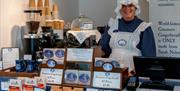 Staff Member Smiling behind the Counter at Grasmere Gingerbread® in Hawkshead, Lake District