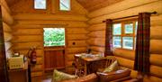 Sofa, dining table, kitchenette, and Dutch door entrance to The Cabin at Grizedale Forest in the Lake District, Cumbria