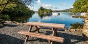 Picnic bench overlooking lake Windermere outside the café and shop at Hill of Oaks Holiday Park in Windermere, Lake District
