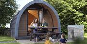 Family Sitting Outside a Glamping Pod at Hollins Farm Holiday Park in Far Arnside, Cumbria