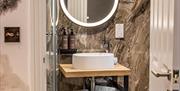 Ensuite bathroom sink and illuminated mirrror at  Hunday Manor Country House Hotel in Workington, Cumbria