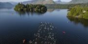 Visitors swimming at Keswick Mountain Festival in the Lake District, Cumbria