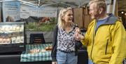 Visitors at a Stall at Keswick Saturday Market in the Lake District, Cumbria