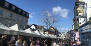 Visitors and Stalls at Keswick Saturday Market in the Lake District, Cumbria