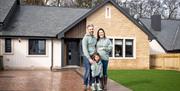 Family Standing Outside Rose Cottage by Lakes For All in Penrith, Cumbria