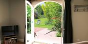 Double doors leading to the garden and outdoor seating at The Cottage at Linden Farm House in Langwathby, Cumbria