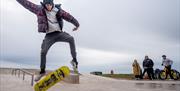 Visitor doing skateboard tricks at Maryport Skate Park in Maryport, Cumbria