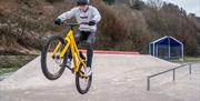 Visitor riding a BMX bike at Maryport Skate Park in Maryport, Cumbria