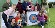 Visitors Posing with an Archery Target with Michael Coates Clay Shooting in the Lake District, Cumbria