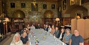 Guests sat for tea in the Dining Room at Muncaster Castle & Gardens in Ravenglass, Cumbria