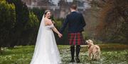 Bride and Groom Posing with Scenery at Muncaster Castle in Ravenglass, Lake District