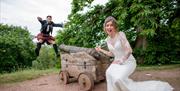 Bride and Groom Posing for a Funny Photo with a cannon at Muncaster Castle in Ravenglass, Lake District