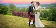 Bride and Groom Posing with Scenery at Muncaster Castle in Ravenglass, Lake District