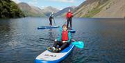 Visitors Paddleboarding in the Lake District with Path to Adventure