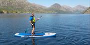 Visitor Paddleboarding in the Lake District with Path to Adventure