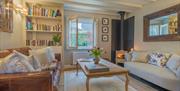 Guest Lounge with Two Couches, Bookshelves, and Wood Burner at Haven Cottage in Ambleside, Lake District