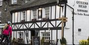 Cyclist Outside of The Queens Head in Hawkshead, Lake District