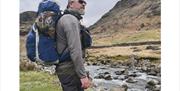 Customer walking with Rigged and Ready fishing rods packed for transport