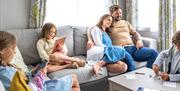 Family Lounging in a Lodge at Solway Holiday Park in Silloth, Cumbria