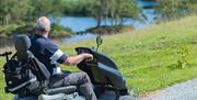 Visitor Using a Mobility Scooter at Tarn Hows in the Lake District, Cumbria