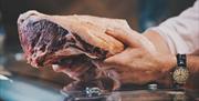 Butcher working at Tebay Services Farmshop and Kitchen in Tebay, Cumbria