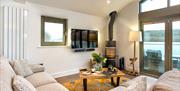 Waterbird Boathouse sitting area with woodburner at Hill of Oaks in Windermere, Lake District