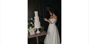 Bridal Couple cutting the wedding cake at a Wedding at The Ro Hotel in Bowness-on-Windermere, Lake District