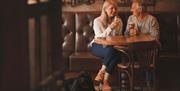 Visitors with a dog enjoying drinks at The Ullswater Inn in Glenridding, Lake District