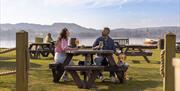 Couple and dog having drinks outside at The Wateredge Inn in Ambleside, Lake District