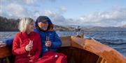 Couple Enjoying the Views from a Heritage Boat on Lake Windermere at Windermere Jetty Museum in Bowness-on-Windermere, Lake District