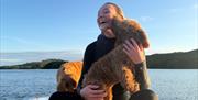 Visitor and dog on a wakeboarding experience with Wake District on Lake Windermere in the Lake District, Cumbria